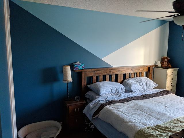 Bedroom with a geometric accent wall in two blues and white