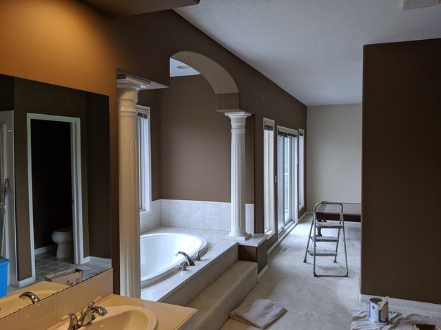 Ensuite bathroom repainted in rich brown with white columns and arches